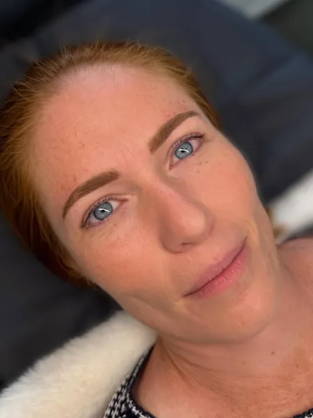 Client with natural nano brows in warm reddish tones